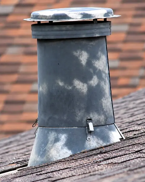 Before: a bare, weathered metal pipe vent with a cap, tile roofing blurred in the background