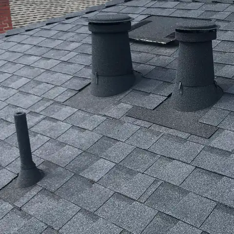 Dark grey stone coated vents on a grey shingle roof