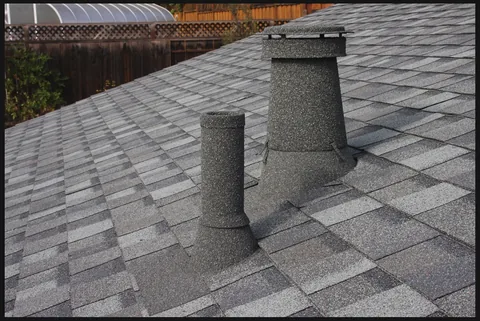 Two stone coated vent stacks on grey shingles
