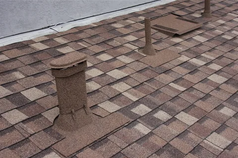 Brown stone coated vent, sleeve and flat vent on brown shingles