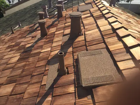 Stone coated vents and a flat vent on a wood shake roof
