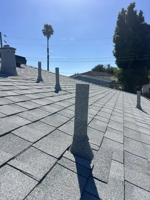 A row of stone coated pipes on a grey roof