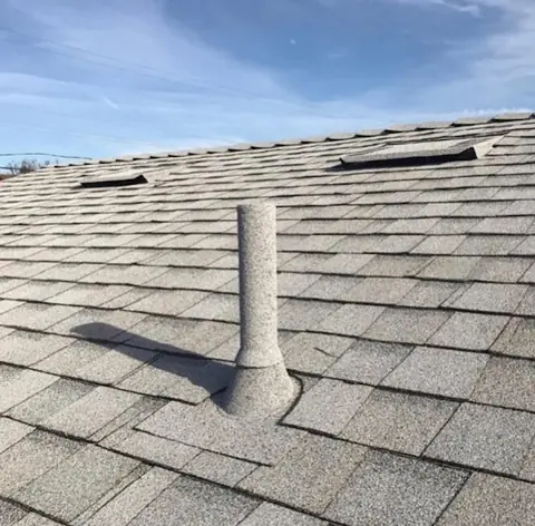 Light grey stone coated pipe sleeve on light grey shingles
