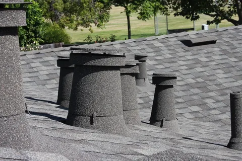 Shadow grey stone coated vents and sleeves on a grey shingle roof