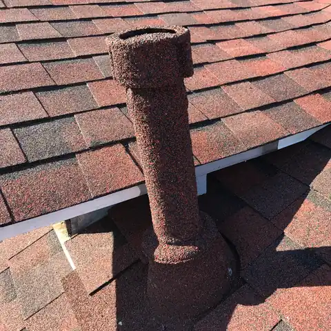 Red stone coated double wall vent pipe on red blend shingles