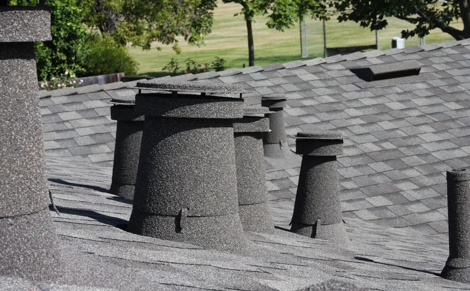 Shadow grey stone coated vents and sleeves on a grey shingle roof, park behind