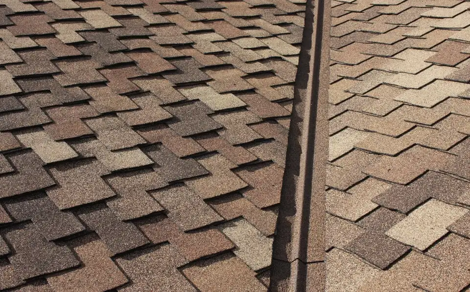 Stone coated valley metal running down a brown blend shingle roof